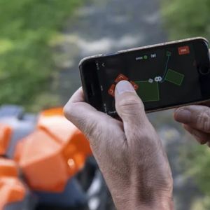 someone controlling a robot mower through a smartphone app