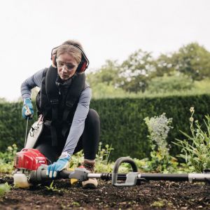 a woman starting up a petrol multi tool