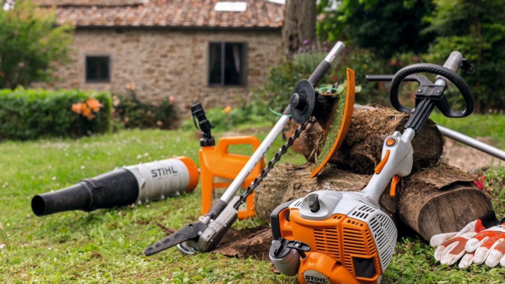 the STIHL KM 56 RC-E KombiEngine and multi tool attachments resting against some logs