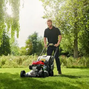 a man mowing the lawn with a petrol lawnmower