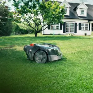 the Husqvarna 105 Automower cutting a lawn, with a house in the background