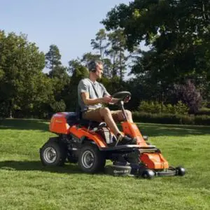 a man operating an orange ride on mower