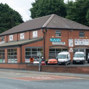 a garden machinery showroom and service centre with vans and a ride-on mower parked outside