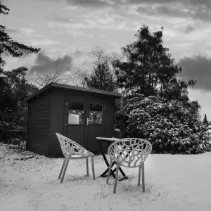 a shed and outdoor furniture in a snow-covered garden