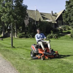 a man mowing a lawn sat on a zero turn mower