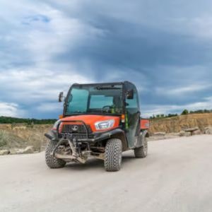 the Kubota RTV-X1110 Utility Vehicle driving down a dirt track in the wilderness