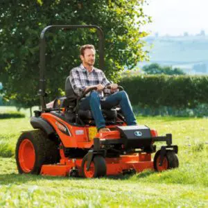 a man mowing a field using an orange zero turn mower