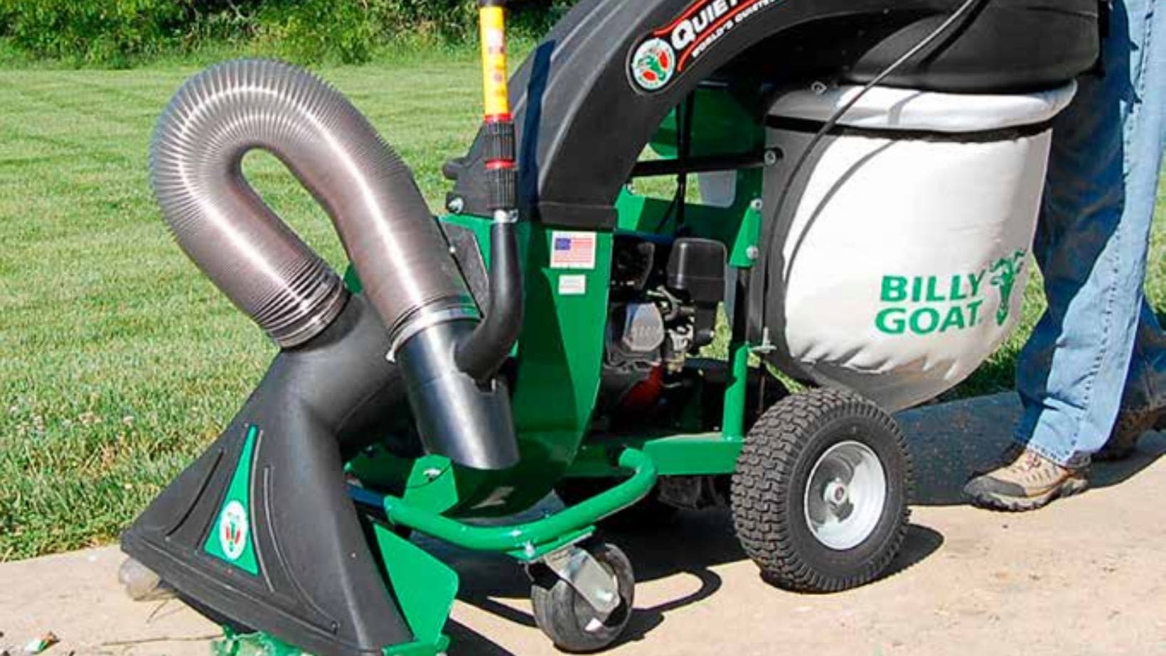 someone using a green Billy Goat leaf and litter vacuum on a path