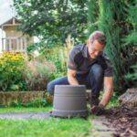 a man covering a robot mower charging station