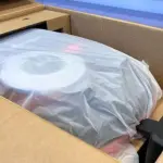 a robot mower in a protective cover, inside a box