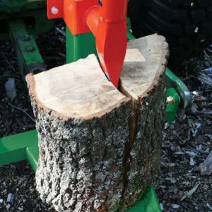 a close up of a tractor-powered wood cutting machine's axe splitting a large log
