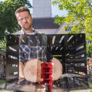 a frontal shot of a man standing behind the AL-KO Easy LSH 5205 Electric Log Splitter, while it splits a log