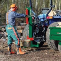 a man in a hard hat, cutting a log using the Wessex LS100 Tractor Mounted Log Splitter