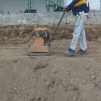 a man operating a wacker plate on a building site