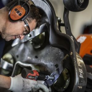 a man tightening a screw on a piece of garden machinery