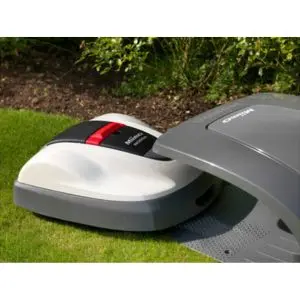 a Honda Miimo robotic lawnmower coming out of a shaded charging station