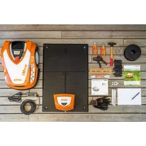 a STIHL iMow robotic mower and full installation kit on a wooden surface