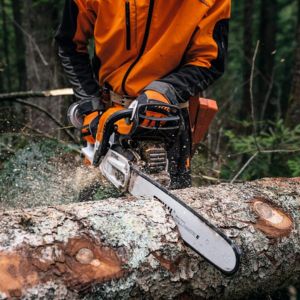 a close-up of someone in orange PPE using a STIHL MS 400 Petrol Chainsaw to cut a log