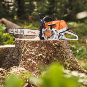 the STIHL MS 400.1 Petrol Chainsaw sat on a tree stump in a forest