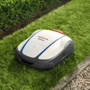 the Honda Miimo 1500 Robotic Mower on a narrow stretch of lawn between a hedge and gravel path