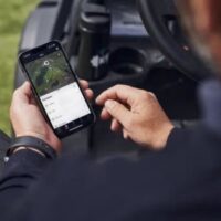 a man using a robot mower app on his smartphone