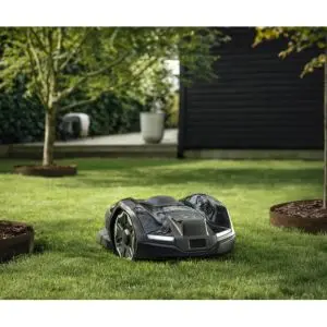 a Husqvarna Automower® 405XE NERA Robotic Mower navigating around small trees on a lawn
