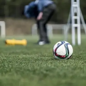 a football, groundsman and turf care equipment on a training pitch