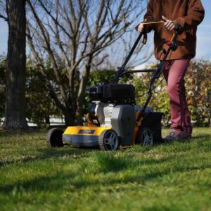 a man operating the STIGA SVP 40 G Petrol Lawn Scarifier