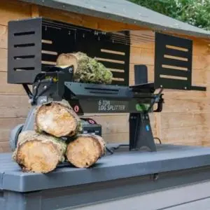 the Handy THLS-6G Log Splitter on a workbench, in a garden, with one log in the machine and three next to it