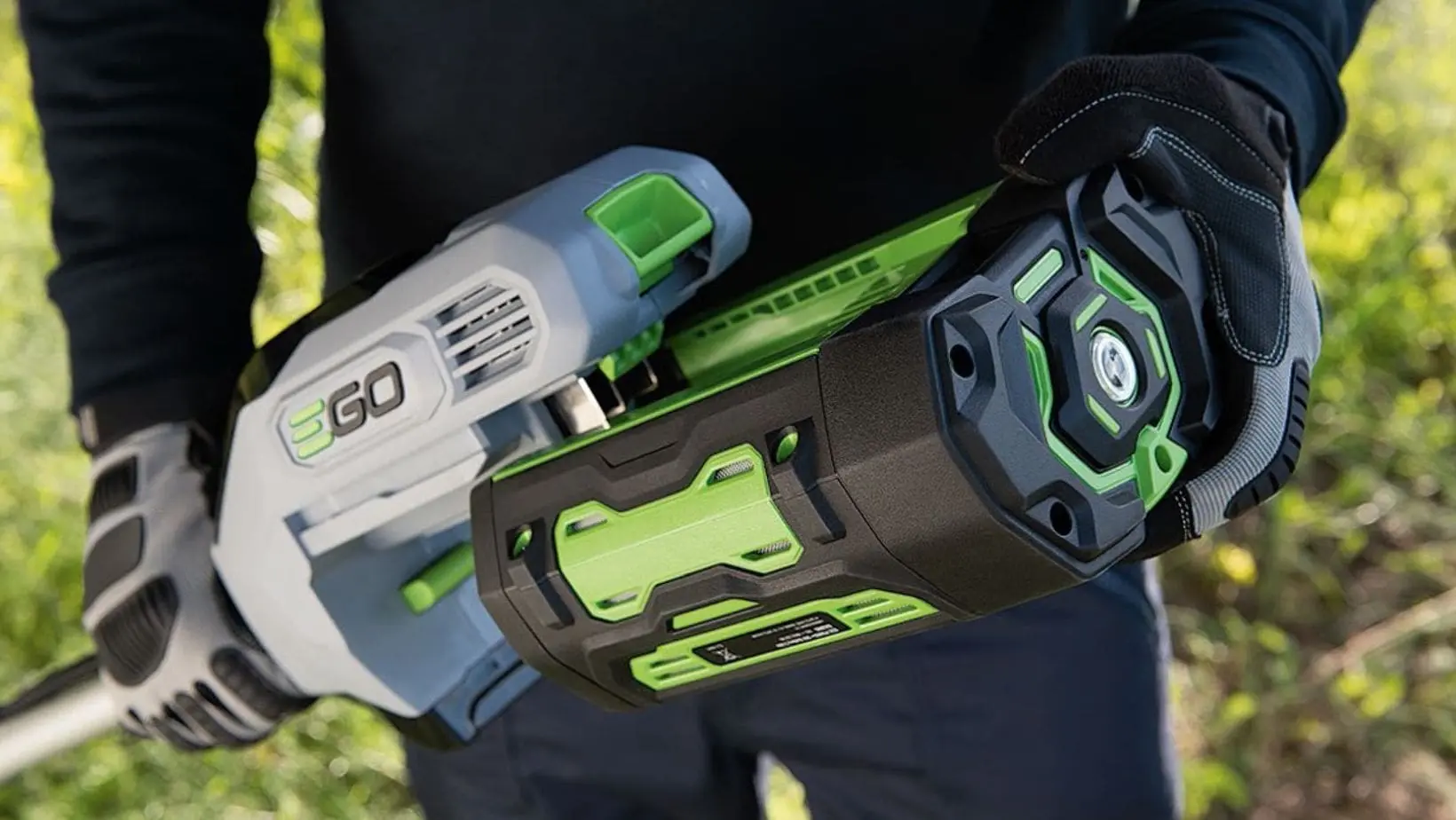 a close-up view of a man holding an EGO cordless multi tool power head with a battery attached
