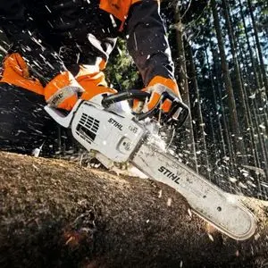 a close up of a STIHL chainsaw being used to cut a log