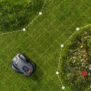 an overhead shot of a Husqvarna Automower® 410XE NERA Robotic Mower on a lawn, with computer-generated graphics demonstrating how its GPS navigation system works