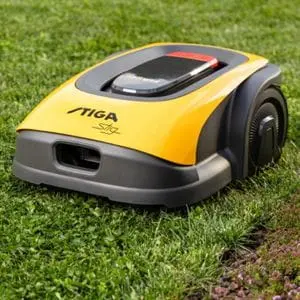 a yellow STIGA Vista Robotic Mower on a lawn, next to a border