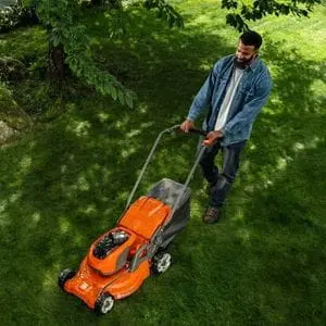 an overhead shot of a man pushing the Husqvarna LC 347iVX Cordless Mower across a lawn, under the shade of a tree