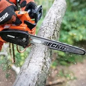 a close up of someone using an ECHO chainsaw to cut a log