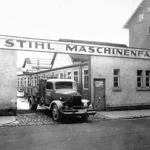an old black and white photograph of a lorry leaving a STIHL factory