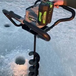 someone using the EGO PHA7404E Cordless Earth and Ice Auger to drill holes in ice