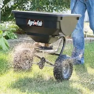 the Agri-Fab 45-0531 Deluxe Push Spreader dispensing lawn seed