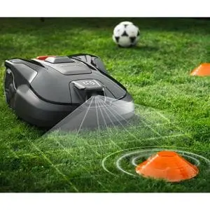a robot mower near 2 small orange cones and a football, with a computer graphic showing how the mower's sensors operate