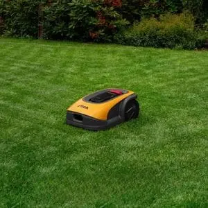 the STIGA A 750 Robotic Mower on a lawn, with a plant bed in the background