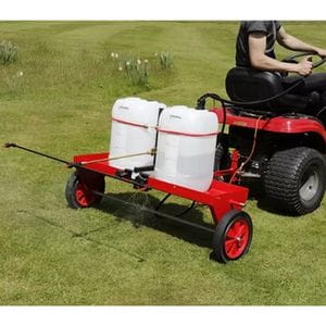 someone using a red ride-on mower to tow the SCH Heavy-Duty Carrier Frame and HGPS Sprayer across a lawn