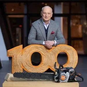 Dr Nikolas Stihl stood behind a STIHL MS 500i Centennial Edition Chainsaw and sculpture commemorating 100 years of STIHL