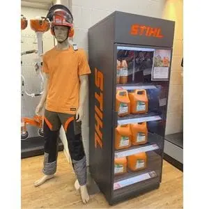 a mannequin dressed in STIHL chainsaw PPE, alongside STIHL bottled fluids in a display cabinet