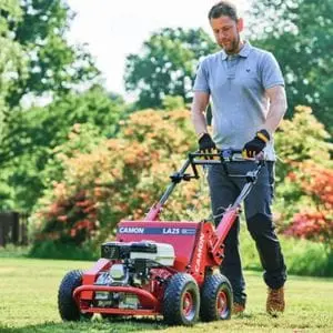 a man aerating a lawn using the Camon LA25 Petrol Lawn Aerator