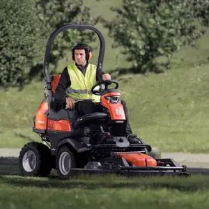 a man wearing a yellow high-visibility jacket and ear defenders, operating the Husqvarna P 524X Out Front Mower