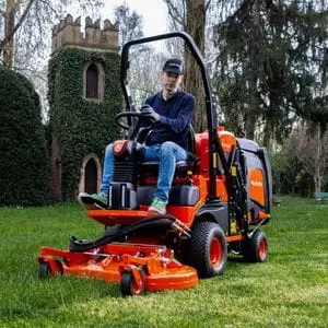 a man cutting grass near a church, using the Kubota FC2-221 Out Front Mower