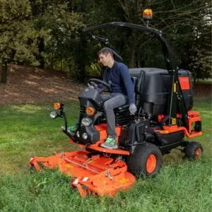 a man cutting grass using an orange Kubota out front mower