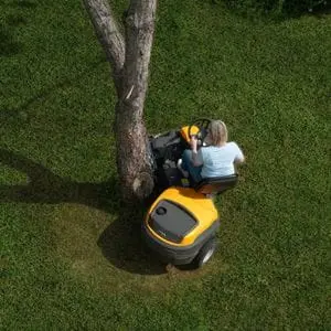a woman cutting grass around the base of a tree, using the articulated STIGA Park 500 Front Mower