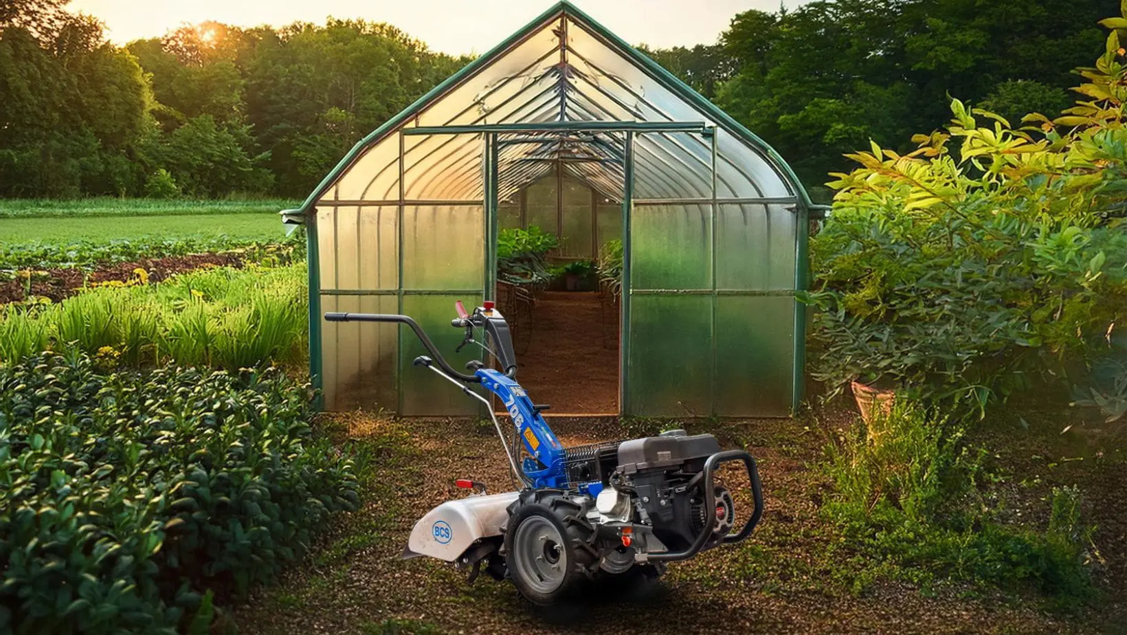 a BCS 706 PowerSafe®2 Wheel Tractor parked outside a greenhouse, in a smallholding