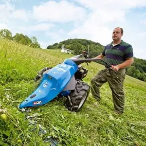a man cutting long grass using the BCS 706 PowerSafe®2 Wheel Tractor with laser cutter bar attachment